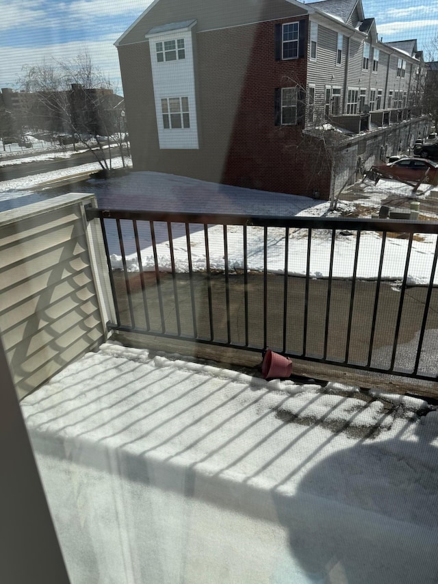 view of snow covered back of property