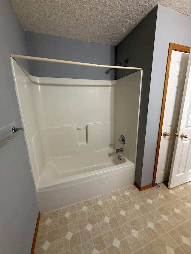 full bathroom featuring shower / bathing tub combination and a textured ceiling