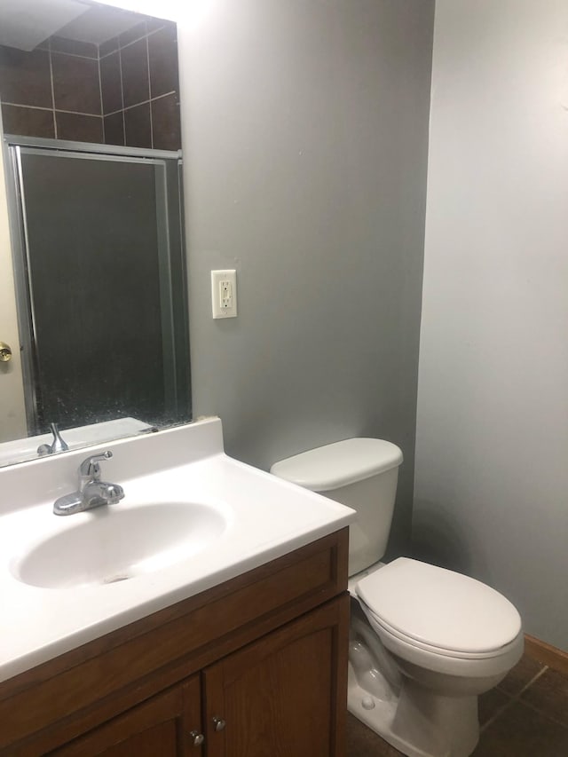 full bath with a shower with door, toilet, vanity, and tile patterned floors