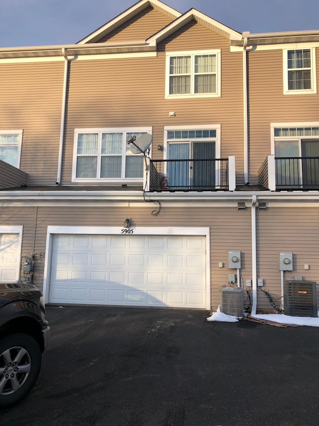 back of house featuring central air condition unit, a garage, and driveway