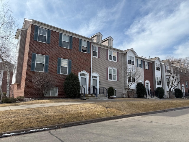 view of property with a residential view and brick siding