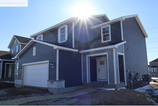 view of front of home with cooling unit and an attached garage