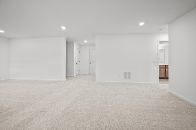 interior space featuring baseboards, visible vents, light colored carpet, and recessed lighting