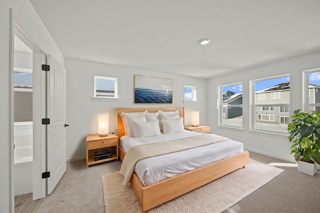 bedroom featuring light colored carpet and baseboards