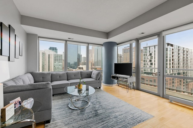 living area featuring visible vents and wood finished floors