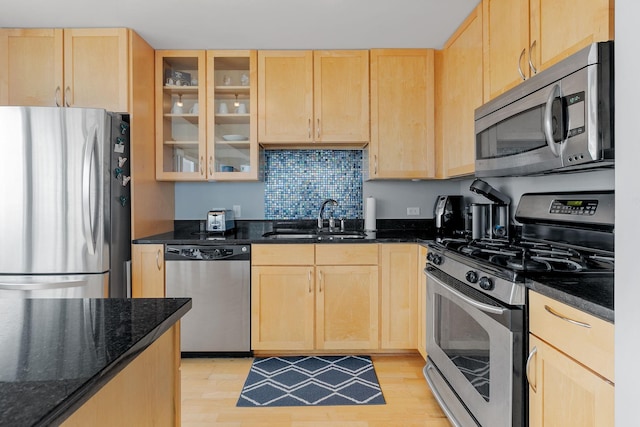 kitchen featuring light wood-style floors, light brown cabinets, appliances with stainless steel finishes, and a sink