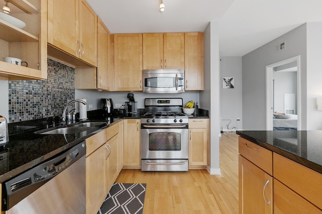 kitchen featuring visible vents, stainless steel appliances, light wood-type flooring, light brown cabinets, and a sink