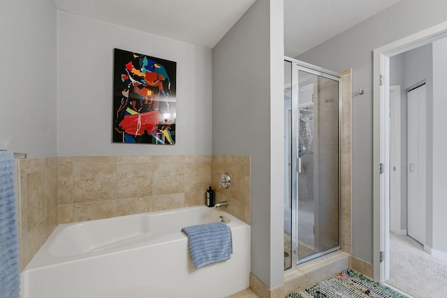 bathroom with a stall shower and a garden tub