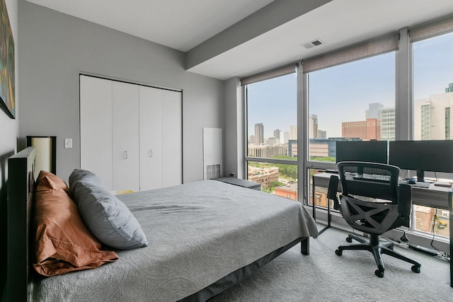 bedroom with carpet floors, floor to ceiling windows, visible vents, and a closet