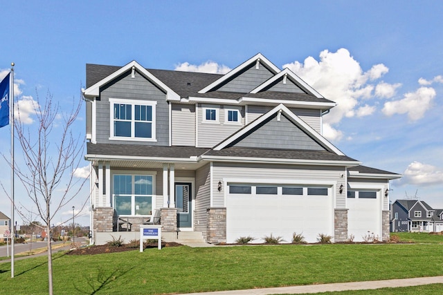 craftsman inspired home with stone siding, a shingled roof, and a front yard