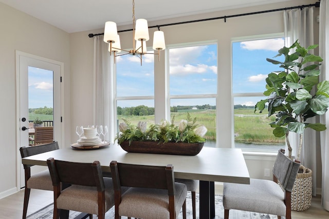 dining area with a chandelier, a healthy amount of sunlight, and light wood-style floors