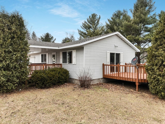 view of side of property with a deck and roof with shingles