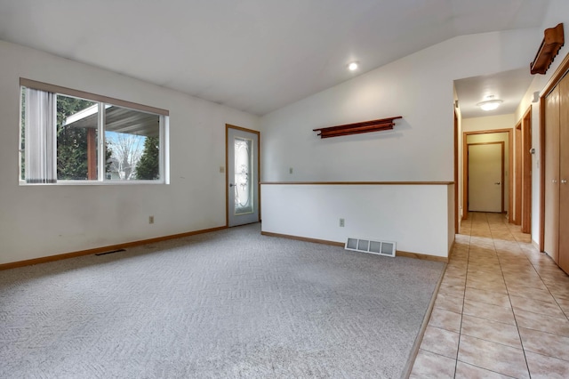 unfurnished room featuring lofted ceiling, visible vents, and light carpet