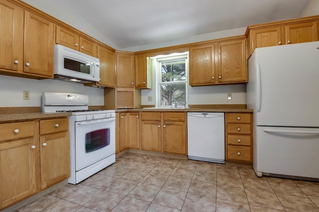 kitchen featuring lofted ceiling, white appliances, a sink, and light tile patterned flooring