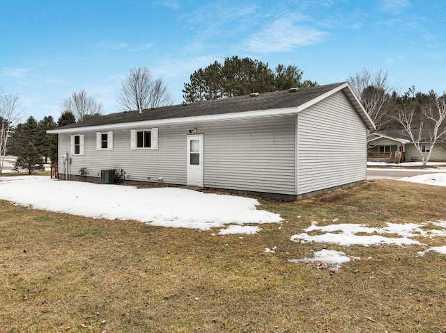 back of property featuring central AC and a lawn