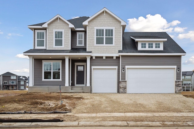 craftsman inspired home with a garage, driveway, and roof with shingles