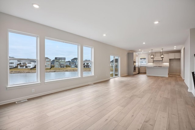 unfurnished living room featuring light wood-style floors, baseboards, visible vents, and recessed lighting