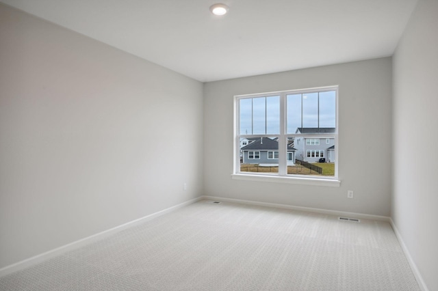 carpeted spare room with baseboards and visible vents