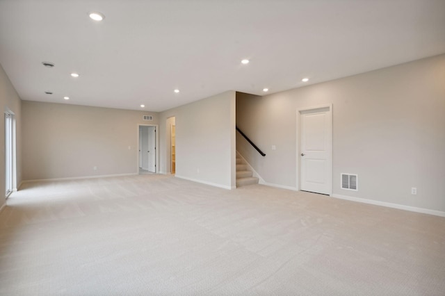 unfurnished room featuring light colored carpet, recessed lighting, visible vents, baseboards, and stairway