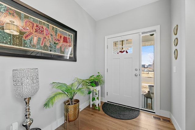 entryway featuring visible vents, baseboards, and wood finished floors