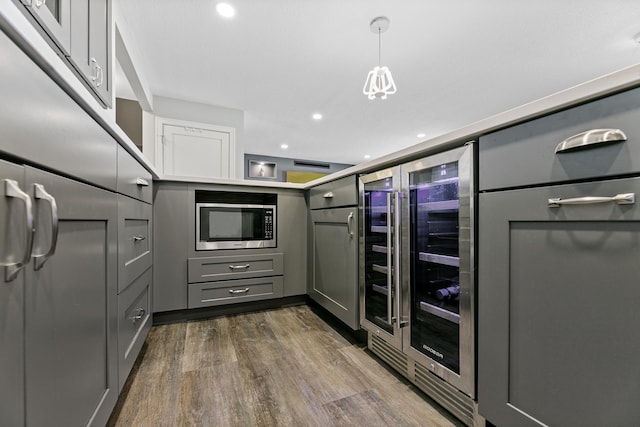 kitchen featuring wine cooler, recessed lighting, gray cabinetry, dark wood-type flooring, and stainless steel microwave