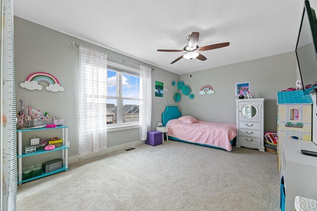 carpeted bedroom with baseboards, visible vents, and a ceiling fan