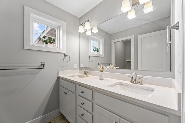 bathroom with a healthy amount of sunlight, a sink, and baseboards