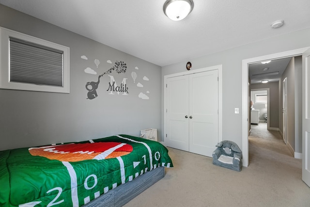 bedroom featuring baseboards, a closet, and light colored carpet