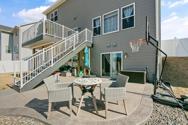 view of patio featuring stairway and fence