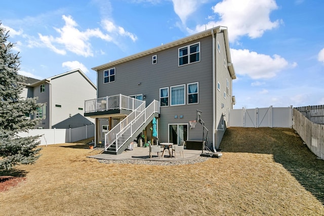 rear view of house featuring a deck, a fenced backyard, stairway, a gate, and a patio area