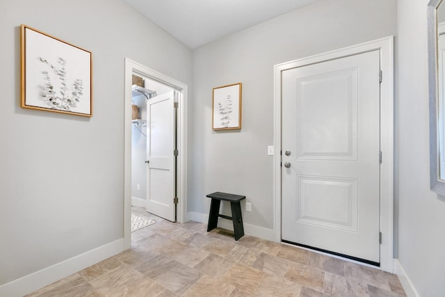 interior space with baseboards and stone finish flooring