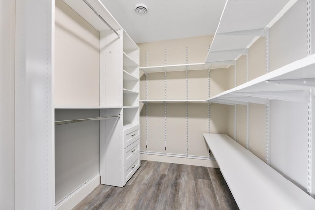 walk in closet with wood finished floors