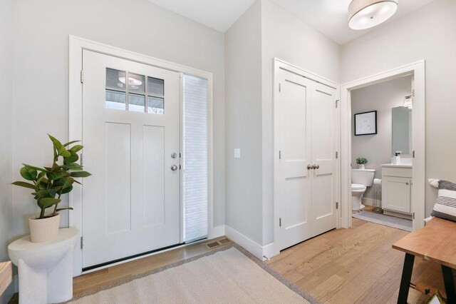 entrance foyer with visible vents, baseboards, and light wood-style floors