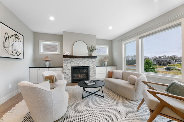 living area with a fireplace, recessed lighting, light wood-style flooring, and baseboards