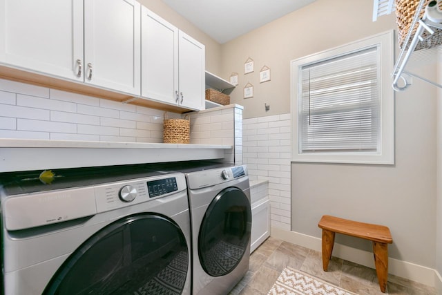 laundry room with separate washer and dryer, cabinet space, and baseboards