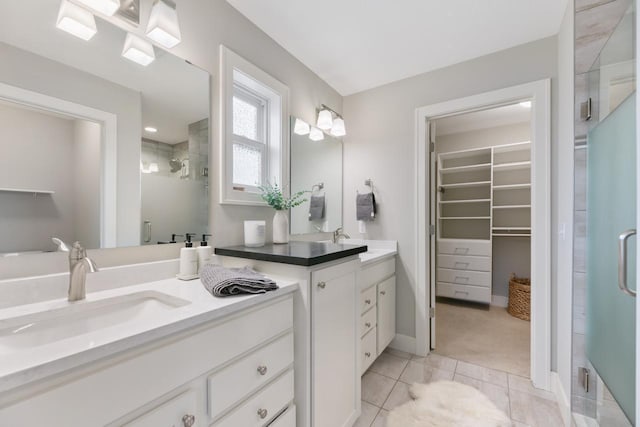 full bathroom featuring tile patterned floors, a spacious closet, a shower stall, and vanity