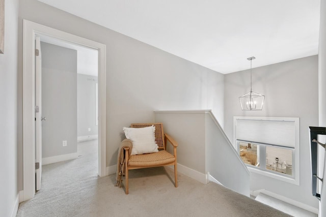 sitting room with carpet flooring, an upstairs landing, a notable chandelier, and baseboards