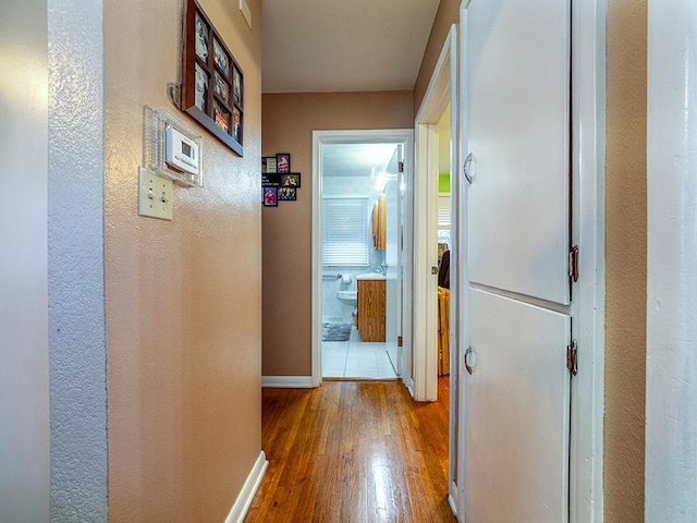 hallway featuring baseboards and wood finished floors