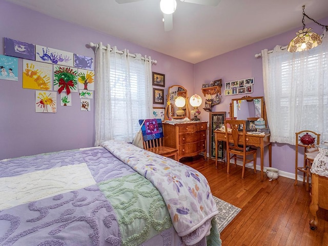 bedroom with wood-type flooring, baseboards, and a ceiling fan