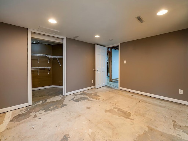 unfurnished bedroom featuring a closet, visible vents, unfinished concrete flooring, and baseboards