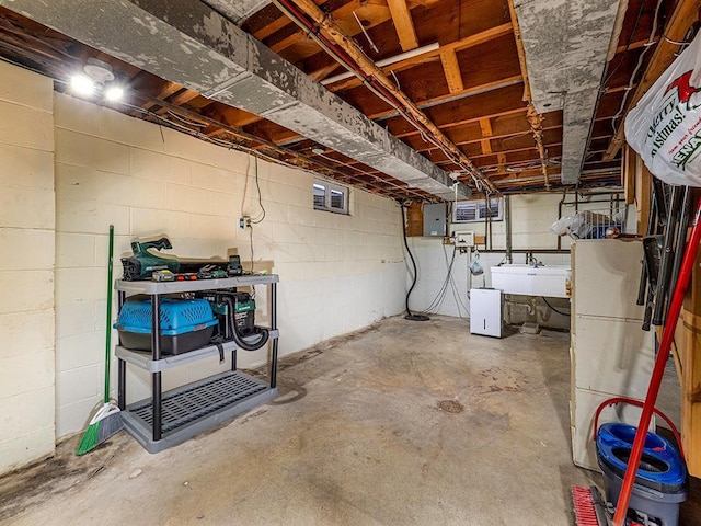 unfinished basement with electric panel and a sink