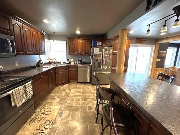 1344 385th Ave, Ten Mile Lake Twp, MN 56218 - kitchen with stainless steel appliances, a sink, dark countertops, recessed lighting, and a breakfast bar