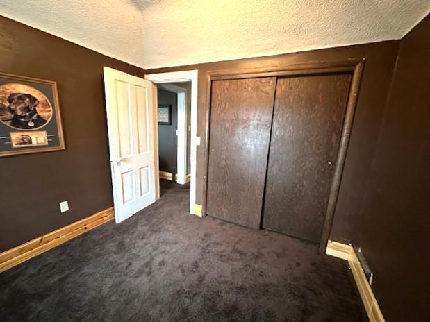 1344 385th Ave, Ten Mile Lake Twp, MN 56218 - unfurnished bedroom with carpet floors, baseboards, a closet, and a textured ceiling