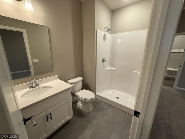 bathroom featuring toilet, a stall shower, and vanity