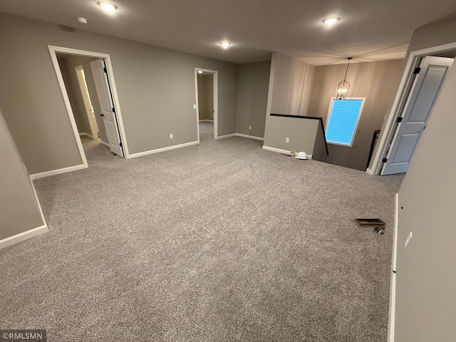 unfurnished room featuring carpet floors, baseboards, and a textured ceiling