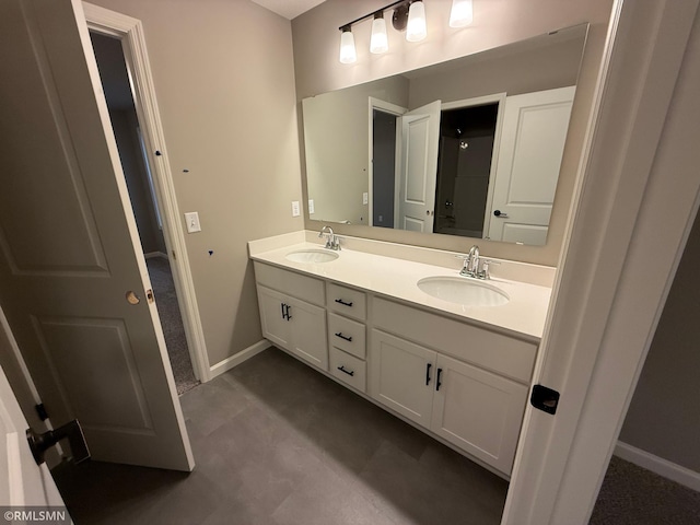 bathroom with double vanity, a sink, and baseboards