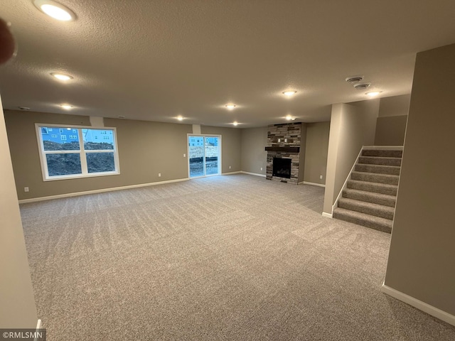 unfurnished living room with baseboards, a fireplace, and stairway