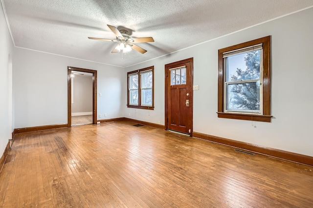 entryway featuring hardwood / wood-style flooring, baseboards, visible vents, and a textured ceiling