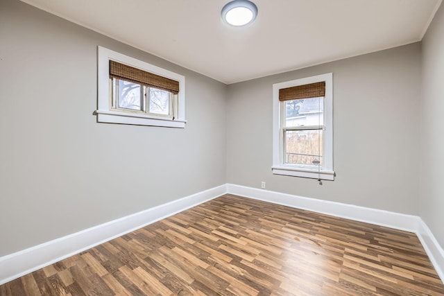 empty room with baseboards and wood finished floors