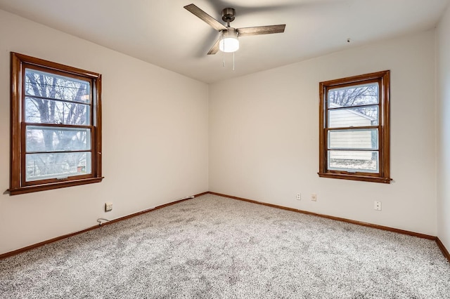 empty room with carpet, ceiling fan, and baseboards